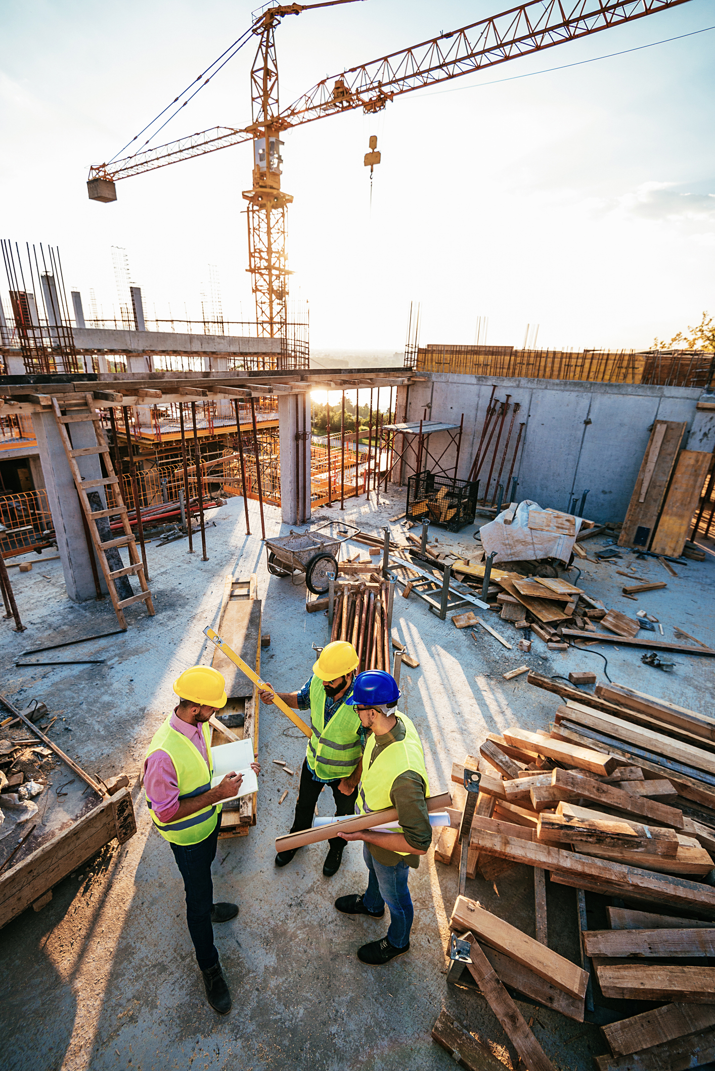 Engineers and contractors on the construction site under crane